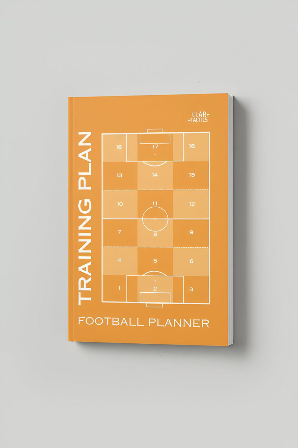 Football planner with training plan design on an orange cover against a gray background