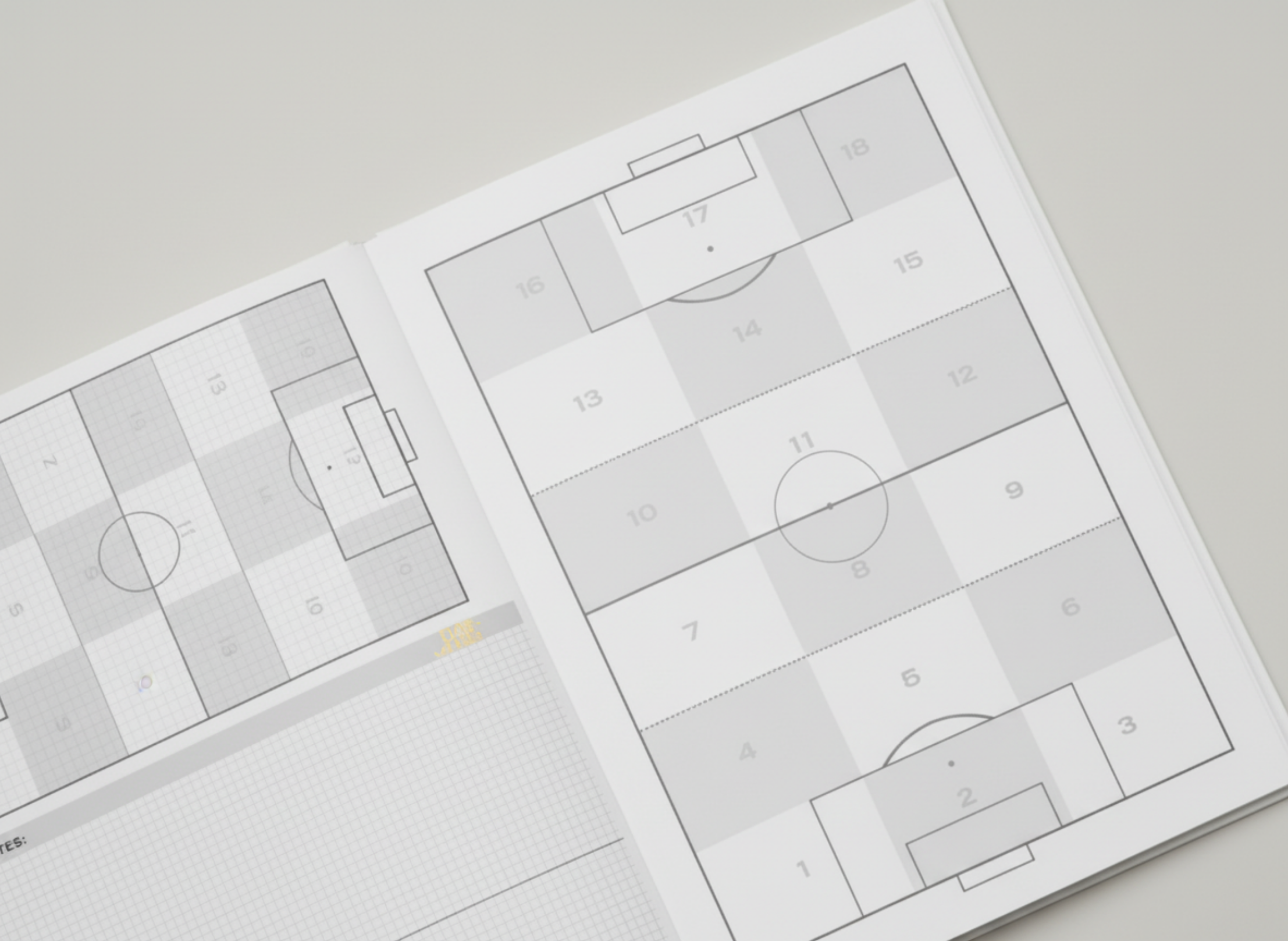 Two sheets of paper with soccer field diagrams on a light gray background