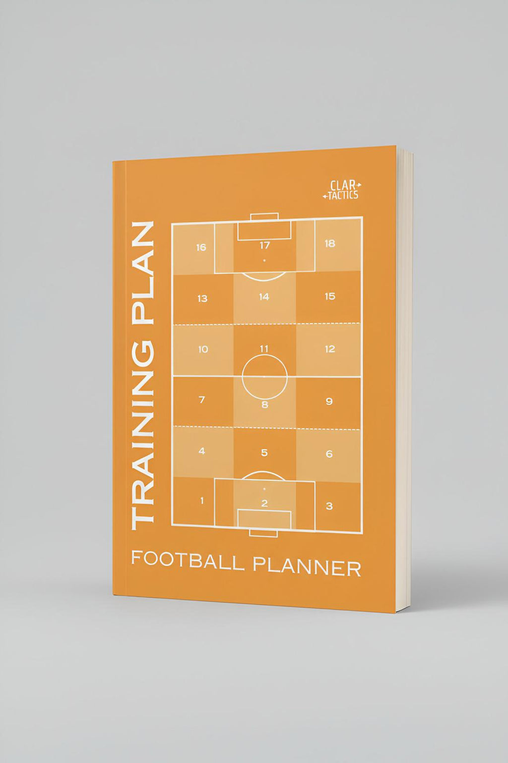 Football training plan planner with soccer field diagram on an orange cover against a gray background